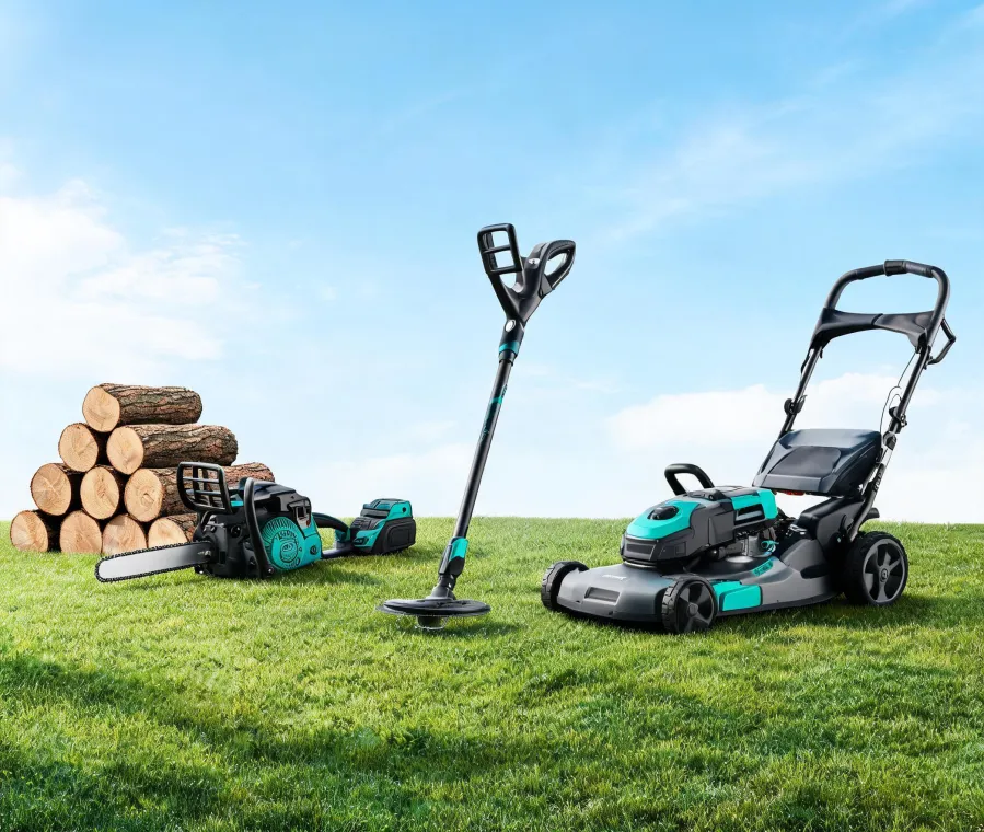 Husqvarna garden tools staged beside trimmed lawn and cut logs